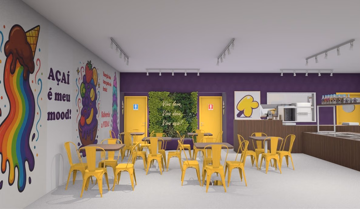 Salão com cadeiras amarelas e mural colorido de açaí